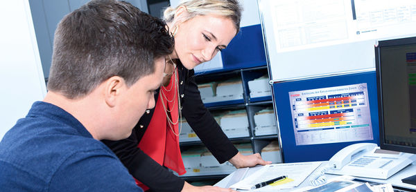 Deux personnes regardent des documents à un bureau